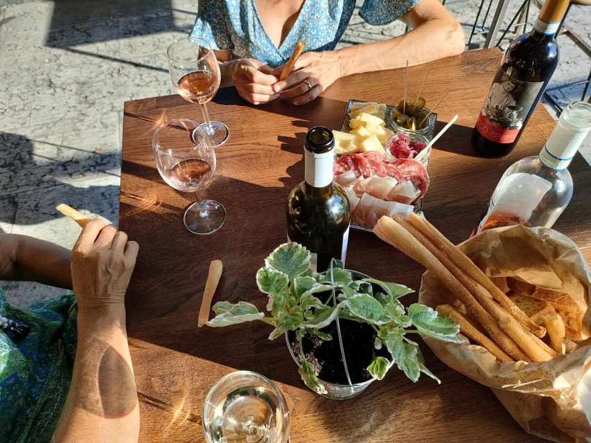 Cavaion: Lake Garda Wine & Food Tasting with Vineyard Tour - Under the grape arbor with a local plate
